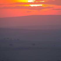 Purple haze sits under blazing dawn sun in the Masai Mara of Kenya, Africa.